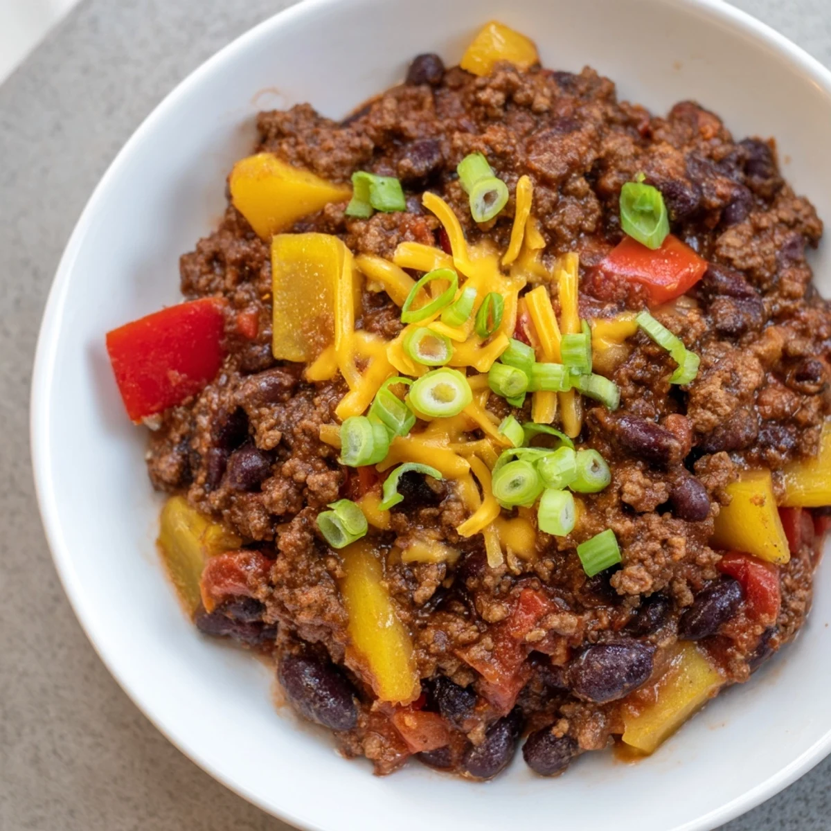 A close-up of a rich, red Simple Weeknight Chili, showcasing beans and ground beef.