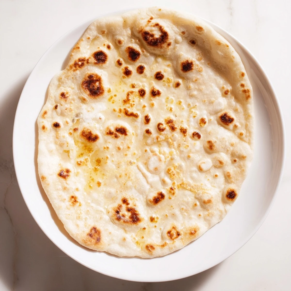 Golden brown Three-Ingredient Easy Flatbreads, ready to be torn and dipped in delicious hummus.