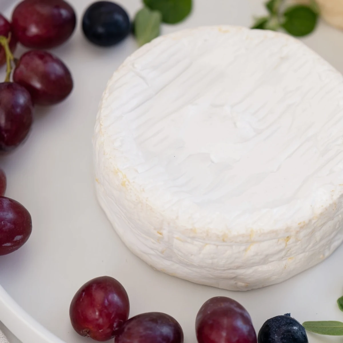 A beautiful cheese wheel is The Floating Island's centerpiece, set on a sea of blue yogurt and grapes.