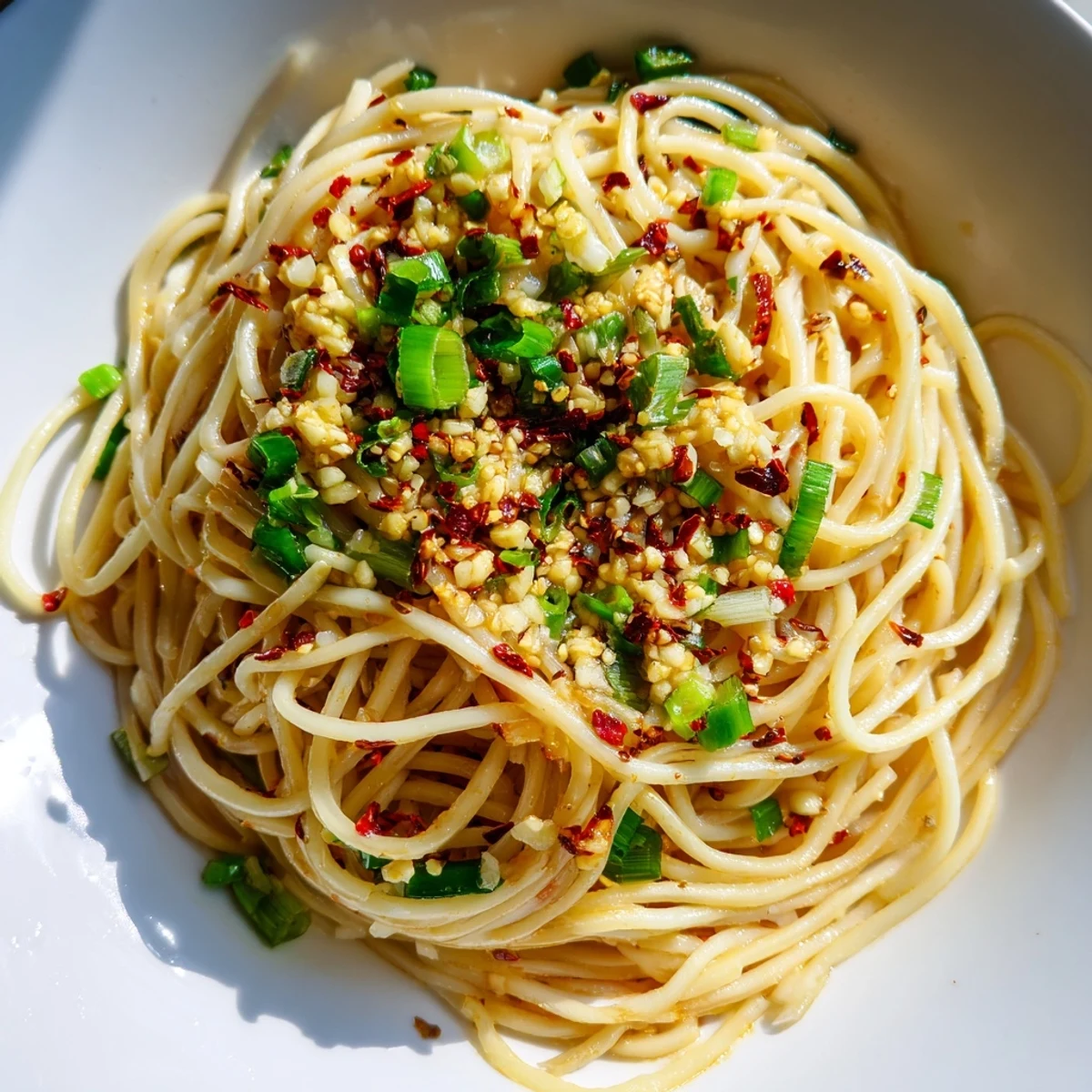 Steaming bowl of Garlic Chili Oil Noodles, a vibrant and fiery Chinese-inspired dish, ready to savor.