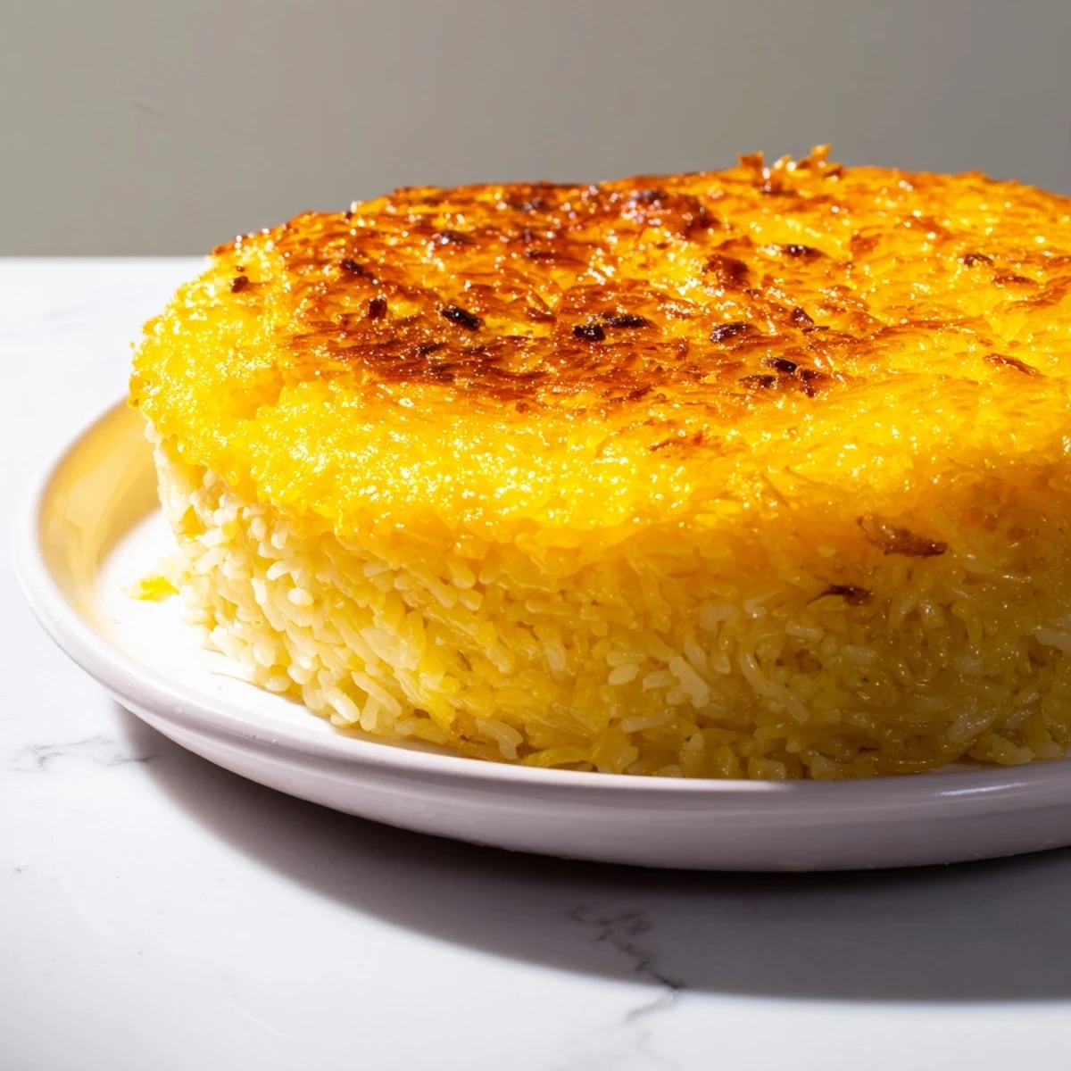 A close up shows the delicious crunchy tahdig base alongside fluffy Persian Tahdig rice.