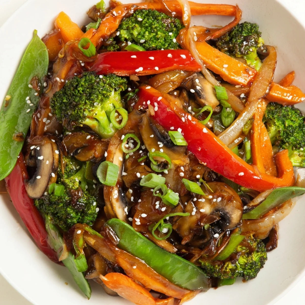 A close-up of Ginger Stir-Fried Vegetables shows colorful bell peppers, mushrooms, and onions glistening with a glossy, ginger-infused sauce.