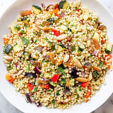 A colorful bowl of Moroccan couscous salad, overflowing with vibrant ingredients and textures.
