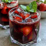 A vibrant, refreshing glass of homemade Starbucks Strawberry Açaí Refresher with fresh strawberries and ice.