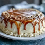 Gold drip graduation sheet cake with mortarboard topper, featuring a smooth vanilla base and shimmering gold accents.