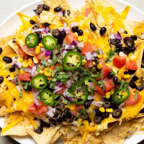 Golden, bubbly sheet pan nachos, loaded with cheese, veggies, and ready for a satisfying bite.