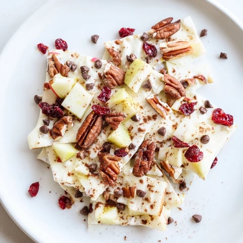 Golden, frosty pieces of Apple Cinnamon Yogurt Bark topped with vibrant apple pieces.