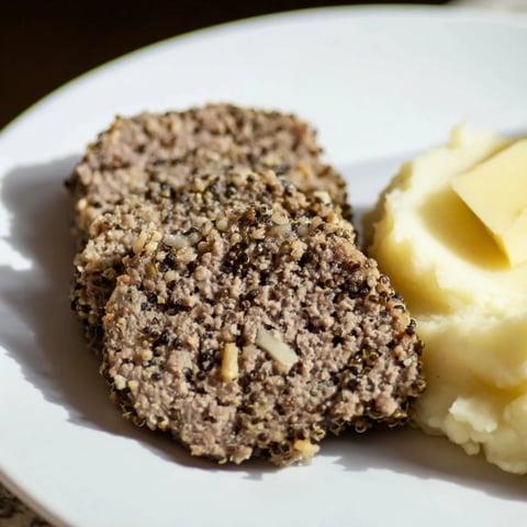 Steaming Scottish haggis, savory pudding bursting with complex flavors, served with mashed neeps and tatties.
