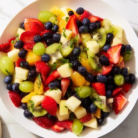 Brightly colored Refreshing Fruit Salad featuring a sweet honey-lime glaze, ideal for summer picnics.