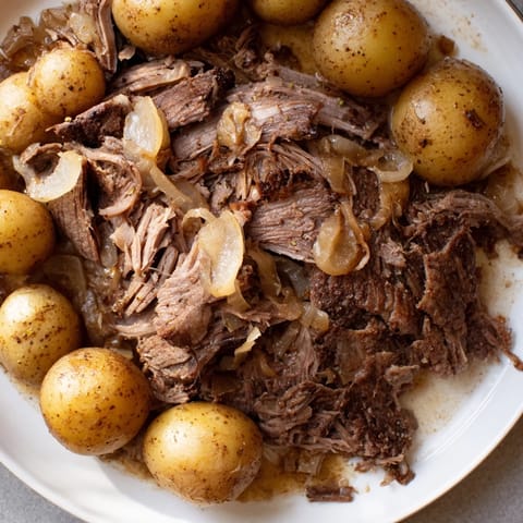 Fork-tender Simple 4-Ingredient Slow Cooker Pot Roast, seasoned with onion soup mix, ready to serve.