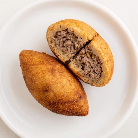 Perfectly fried Lebanese Kibbeh, a traditional Middle Eastern dish with a savory aroma.