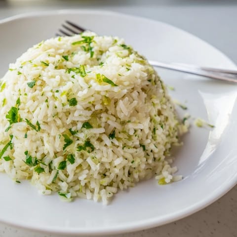 A close-up of fluffy Cilantro Lime Rice studded with bright cilantro, ready to accompany tacos or grilled chicken.