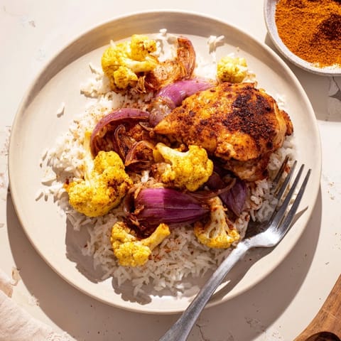 A single-pan meal of succulent chicken and tender cauliflower served over fluffy basmati rice with parsley.