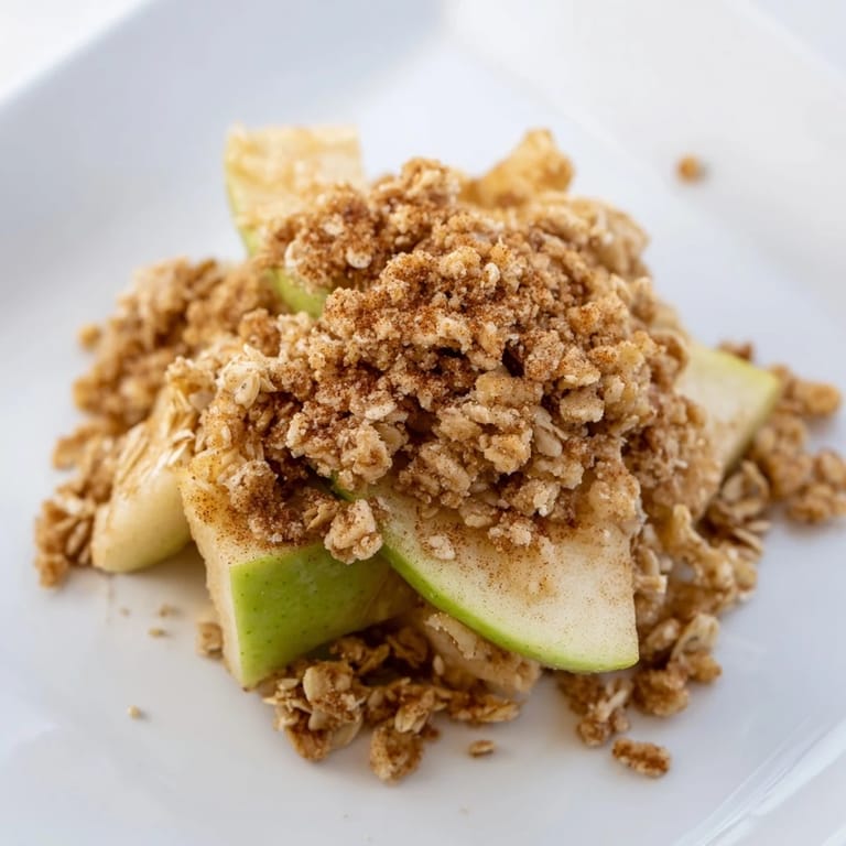 Close-up of freshly baked Rustic Apple and Cinnamon Crumb Bake, a comforting dessert with a crispy topping.