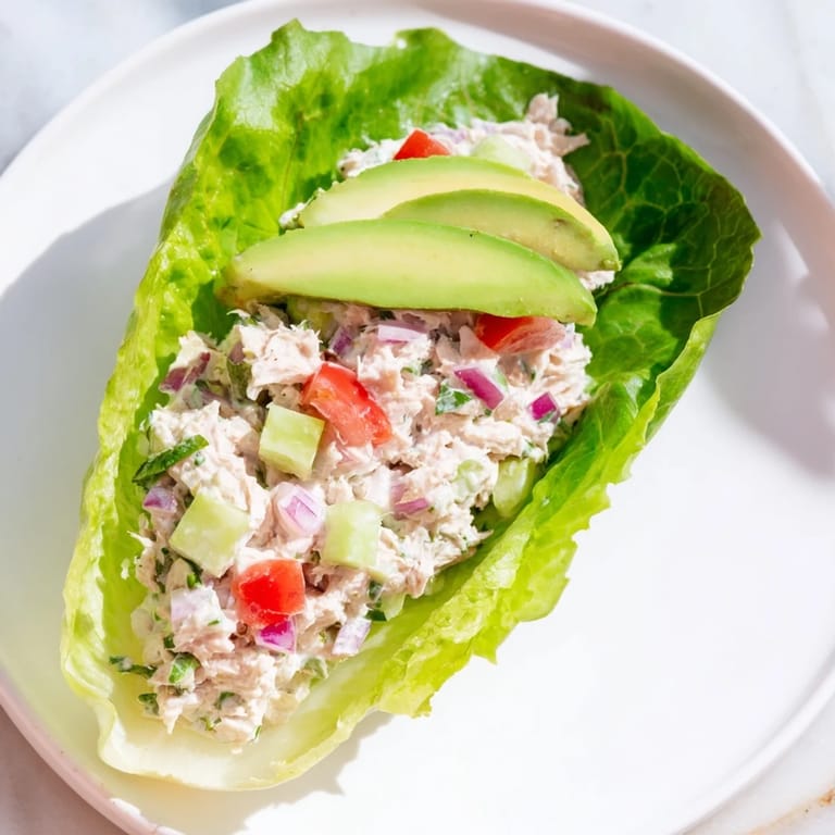 A healthy serving of Quick & Healthy Tuna Salad Lettuce Wraps with fresh tomatoes; a light lunch idea.