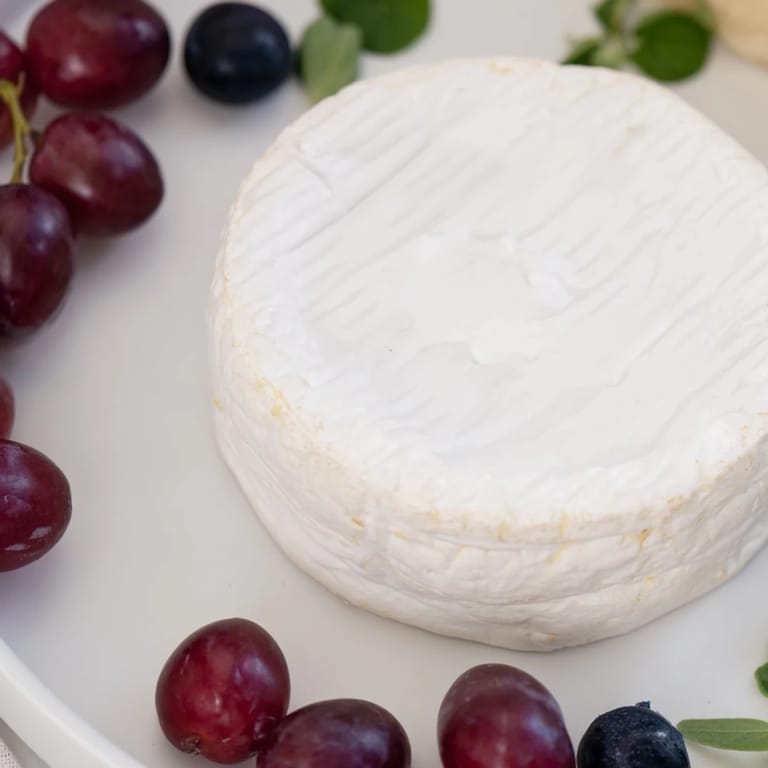 A beautiful cheese wheel is The Floating Island's centerpiece, set on a sea of blue yogurt and grapes.
