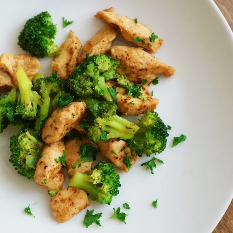 A close-up of vibrant Microwave-Steamed Chicken and Broccoli with seasonings and fluffy parsley, ready to enjoy.
