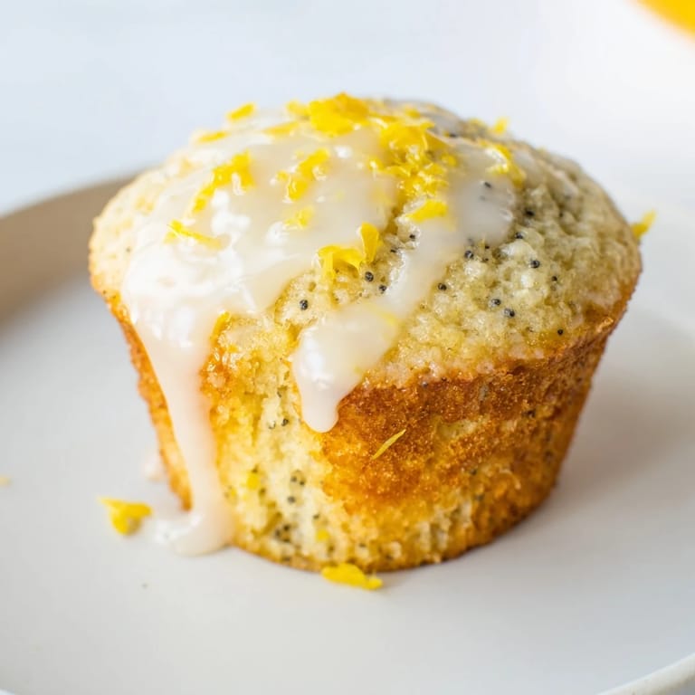 Fluffy Lemon Poppy Seed Muffins drizzled with glaze, perfect to enjoy with a cup of coffee on a sunny morning.