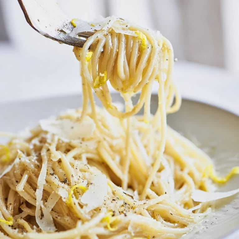 Golden, glossy Lemon Butter Pasta served warm with lemon zest, black pepper, and extra Parmesan on top.
