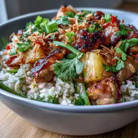 Coconut Pineapple Chicken Rice Bowls with tender chicken, sweet pineapple, and fragrant coconut rice, garnished with fresh herbs and toasted coconut.