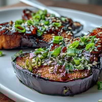 Roasted eggplant halves glazed with sweet and savory miso, caramelized under the broiler for an umami-rich vegetarian side dish.